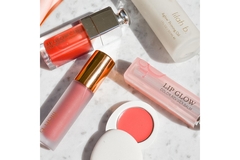 Image Dior Lip Oil and other products together in a pile with other makeup.